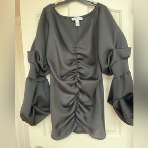 Black cocktail minidress with ruching and balloon sleeves.
